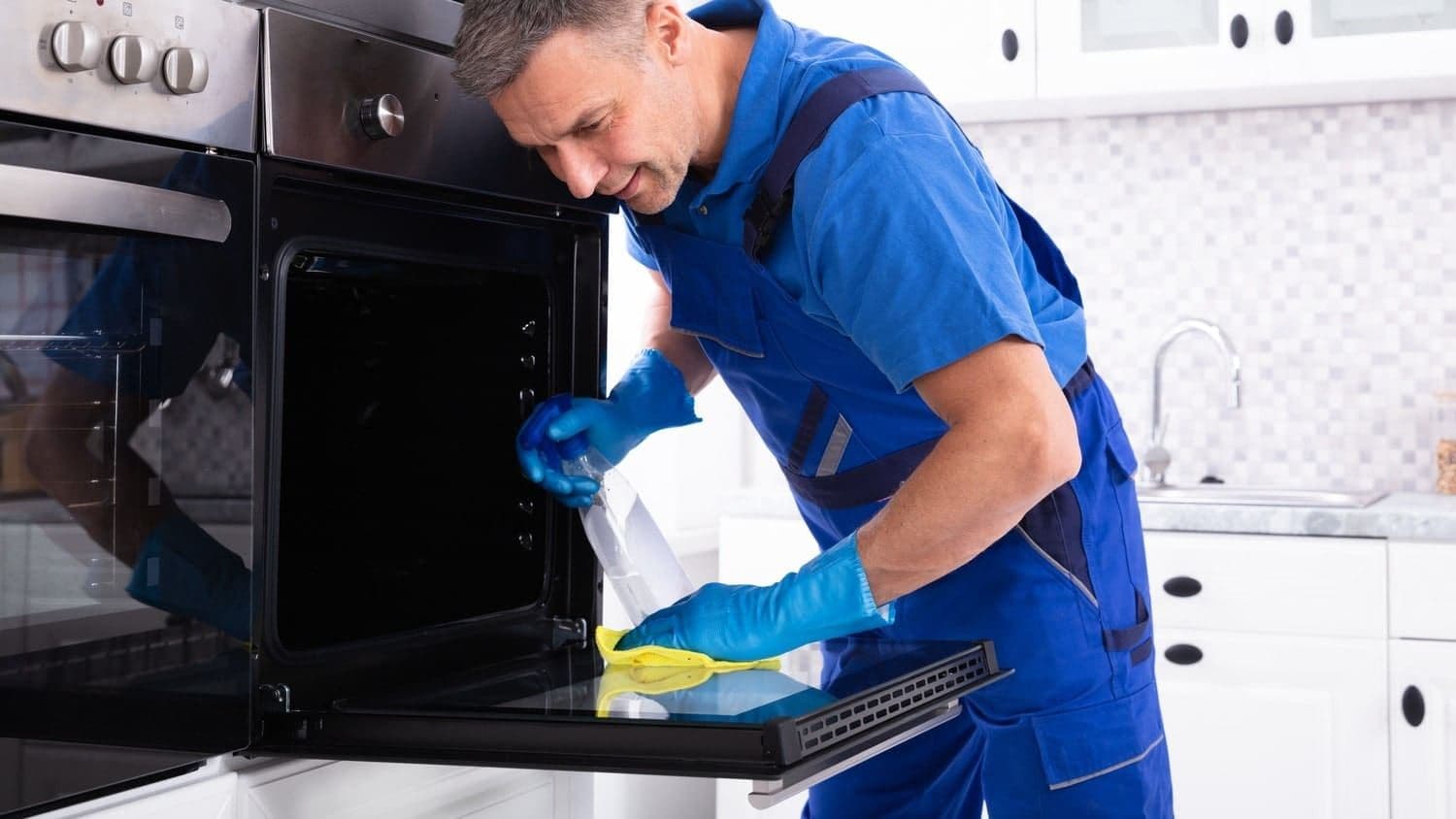Oven cleaning technician degreasing a kitchen oven in a Dublin home